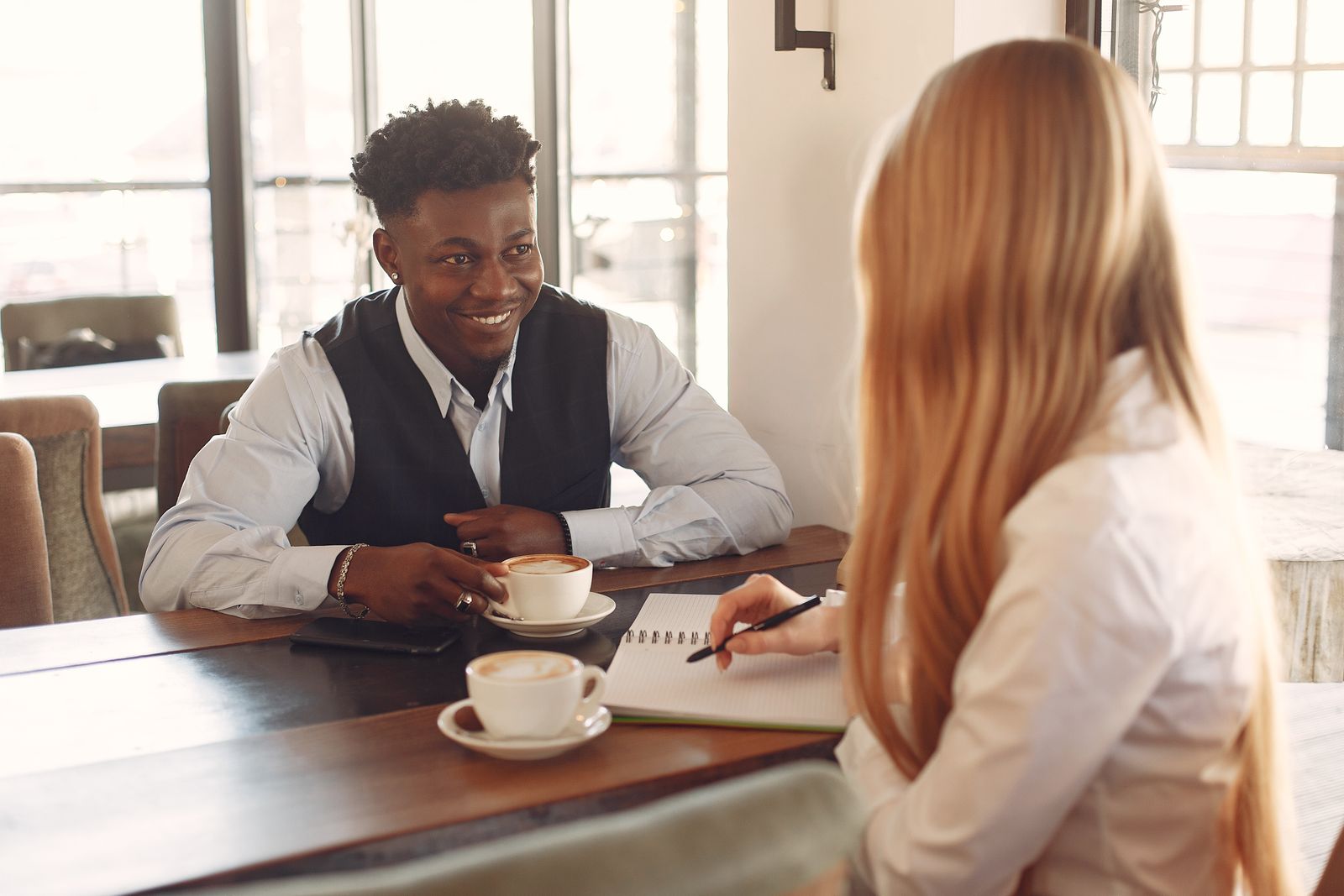 Insurance agent meeting a small business owner over coffee to quote workers comp